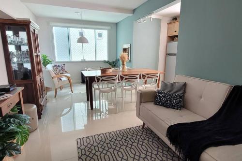 una sala de estar con un sofá y una mesa en Apartamento uma quadra do mar, melhor localização, en Capão da Canoa