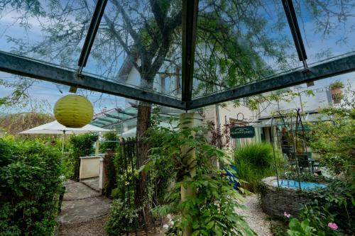 a glass house with a pool in a garden at Ferienhaus Tolazzi in Arnoldstein