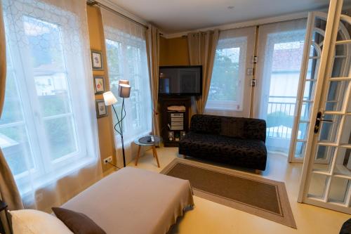 a living room with a couch and a tv and windows at Ferienhaus Tolazzi in Arnoldstein
