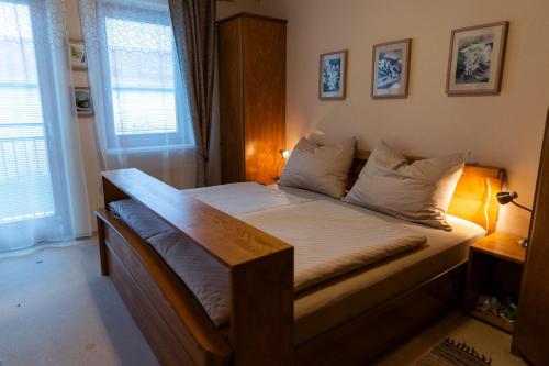 1 dormitorio con 1 cama con marco de madera en Ferienhaus Tolazzi, en Arnoldstein