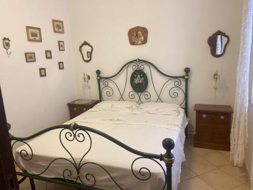 una camera da letto con un letto bianco e nero e alcune immagini di Casa Vacanze - Oliveri - Sicilia a Oliveri