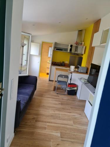 un salon avec un canapé et une cuisine dans l'établissement Dépendance-Appartement dans maison à Montgeron, à Montgeron