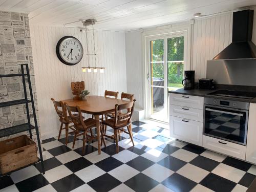 uma cozinha com uma mesa e um relógio na parede em Flemma Gård Wing residence with lake view em Vreta Kloster