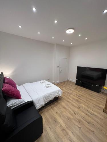 a bedroom with a bed and a flat screen tv at See the Sea Hideaway in The Mumbles