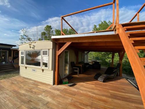 a tiny house with a porch and a deck at Retro house in nature in Šamorín