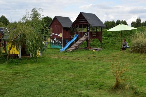 a playground with a slide and an umbrella in a yard at Owczarkowa Zagroda 