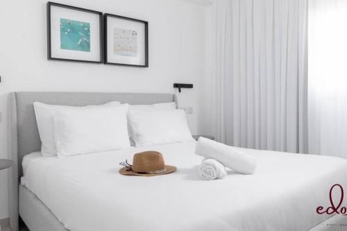a white bed with a hat on top of it at דירת 2 חדרי שינה וסלון 50 מטר מהים- By Edomlux in Eilat
