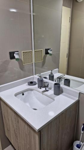 uma casa de banho com um lavatório branco e um espelho. em Departamento Centro Lynch II em Temuco