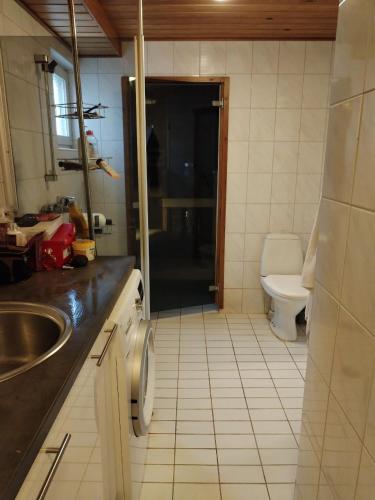 uma casa de banho com um lavatório e um WC em Private room in a house w/ pool em Helsinque