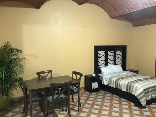1 dormitorio con 1 cama, mesa y sillas en ALOJAMIENTO CAMPESTRE, en Ciudad de México