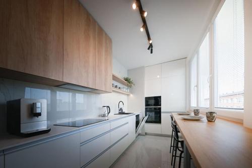 a kitchen with white cabinets and a wooden counter top at Zikovka in Olomouc