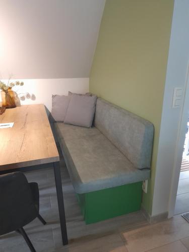 a couch in the corner of a room with a table at L'Écureuil - Terrasses de Malmedy in Malmedy