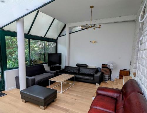 ein Wohnzimmer mit Sofa und Tisch in der Unterkunft Rez de jardin de maison avec grand jardin exclusif in Villejuif