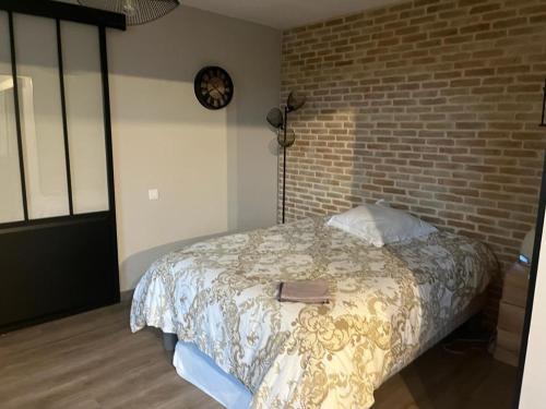 sypialnia z łóżkiem i ceglaną ścianą w obiekcie Résidence pleine nature w mieście Revel