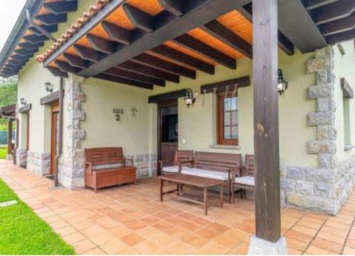 Arboleya的住宿－La puerta de Fredo，房屋内带长凳和桌子的庭院