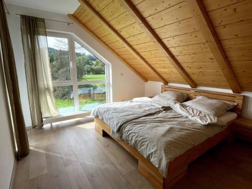 Schleusingen的住宿－Urlaub-Im-Erletal，一张位于带大窗户的房间内的床铺