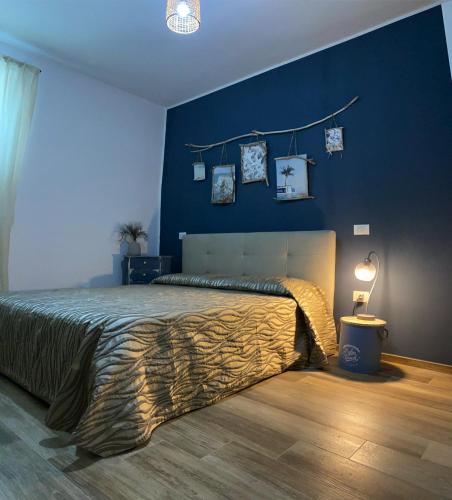 1 dormitorio con 1 cama grande y pared azul en Il rifugio tra gli ulivi en Ortona