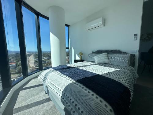 a bedroom with a bed in a room with windows at Top Floor Mountain View Luxury Rental Unit in SkyGarden Glen in Glen Waverley
