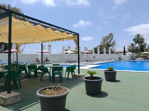 a patio with tables and chairs next to a pool at Casa La Marina in Alcossebre