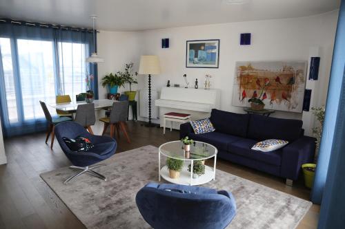 un salon avec un canapé bleu et une table dans l'établissement Duplex grande terrasse, vue sur Canal, à Paris