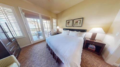 a bedroom with a large white bed and a window at LV112 Delightful Upstairs 1 Bedroom Legacy Villa in La Quinta