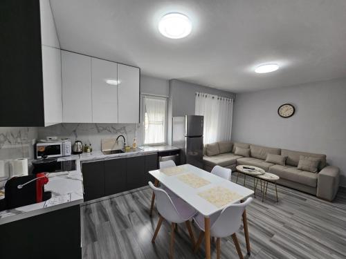 een keuken en een woonkamer met een tafel en stoelen bij Tirana Apartment Comfort Home in Tirana