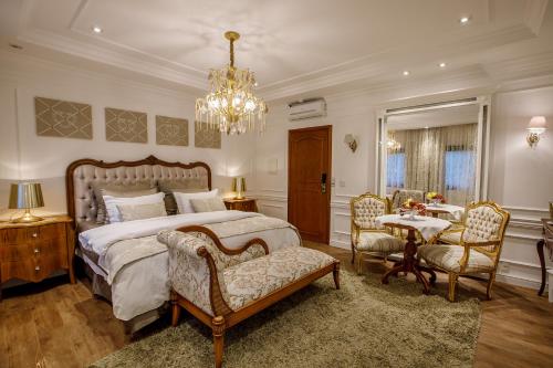 a bedroom with a bed and a table and chairs at Hotel Ritta Höppner in Gramado
