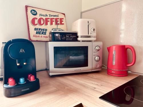 microondas y cafetera en el suelo de la cocina en Cocon Urbain - avec parking privé gratuit, en Toulouse