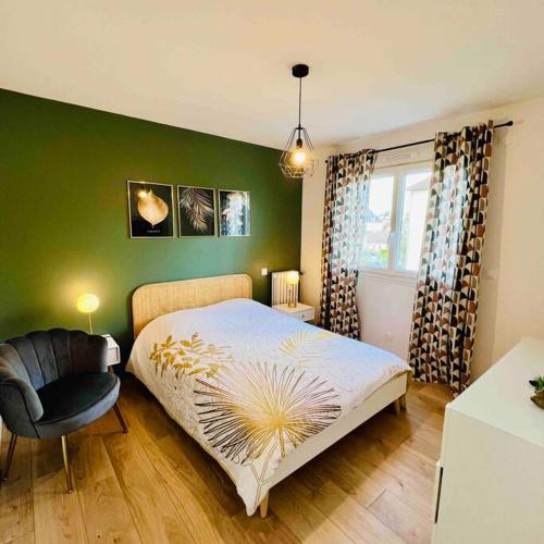 une chambre avec un grand lit et une chaise dans l'établissement Caen : Cocon moderne et chaleureux à 5mn du Centre, à Caen
