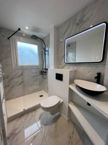 une salle de bain avec toilettes, lavabo et fenêtre dans l'établissement Caen : Cocon moderne et chaleureux à 5mn du Centre, à Caen