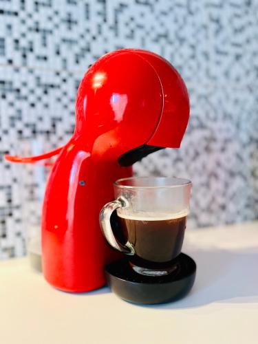 a red coffee maker is making a cup of coffee at Viento Azul Guest House in Punta del Este