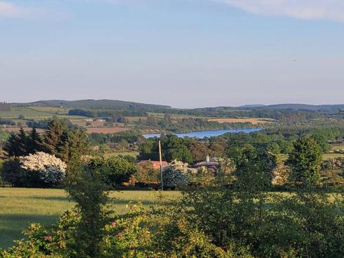 a view of a field with a lake in the distance at Brigadoon 3 bed Apartment with Stunning valley Veiws in Roundwood