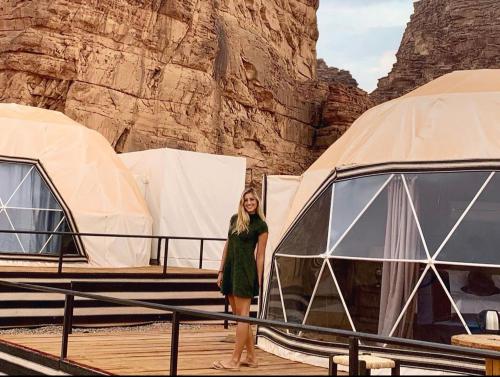 a woman standing in front of a dome tent at SUN LUXURY CAMP &Tour in Wadi Rum