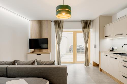 Il comprend un salon avec un canapé et une cuisine. dans l'établissement BALANCE apartments, à Znojmo