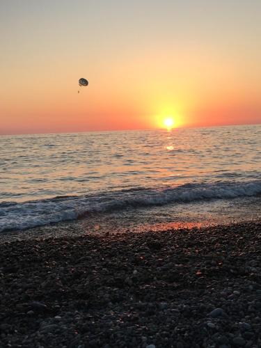 a kite flying over the ocean at sunset at hotel twins G&G in K'obulet'i