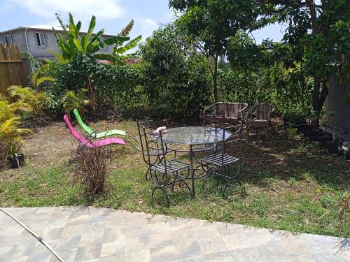 a table and chairs sitting in a yard at Zannanna delair in Sainte-Anne