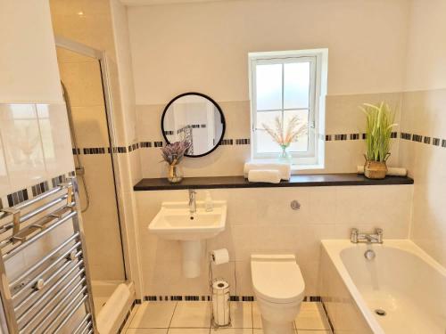 a bathroom with a sink toilet and a window at Spacious Luxury Serviced Apartment Stevenage Free Private Parking & WIFI by Stay Local Home Welcome Contractors Business Travellers Families in Stevenage