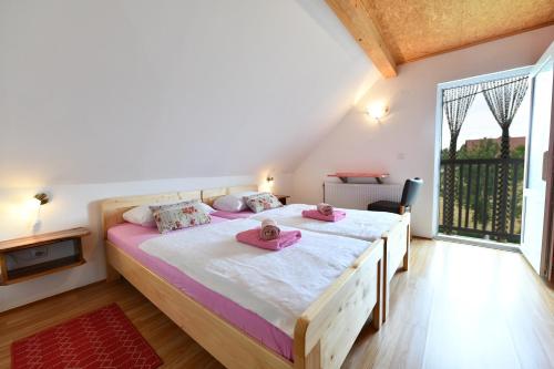 a bedroom with a large bed with pink towels on it at Holiday Home Vukovic in Saborsko