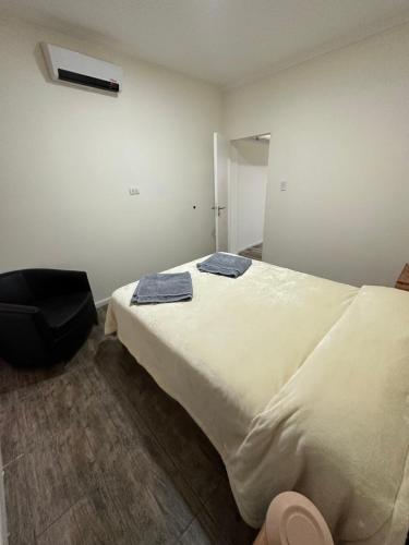 ein Schlafzimmer mit einem großen Bett mit zwei Handtüchern darauf in der Unterkunft Complejo Lila in Mendoza