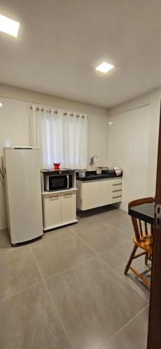 uma cozinha com armários brancos e um frigorífico em Kitnet Aconchego dos Nobres em Domingos Martins