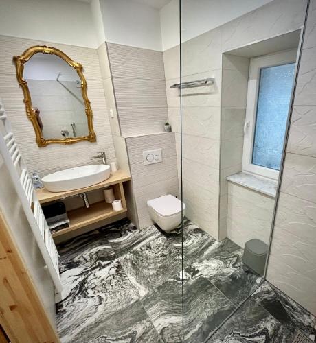 a bathroom with a sink and a toilet and a mirror at OH Apartments & Rooms in Ljubljana