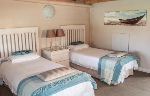 a bedroom with two beds and a boat on the wall at Siesta Guesthouse & Wedding Venue - Frankfort in Frankfort