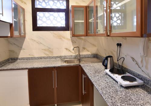 a kitchen with a sink and a counter top at Rihanna Hotel Apartment in Kuwait