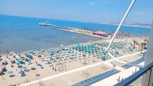 een strand met een stel stoelen en parasols bij Mani Apartment in Durrës