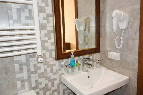 ein Badezimmer mit einem Waschbecken und einem Telefon an der Wand in der Unterkunft Eleon Boutique Hotel in Tbilisi City