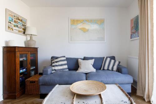 sala de estar con sofá azul y mesa en Sanderling House, walk to beach en Earnley