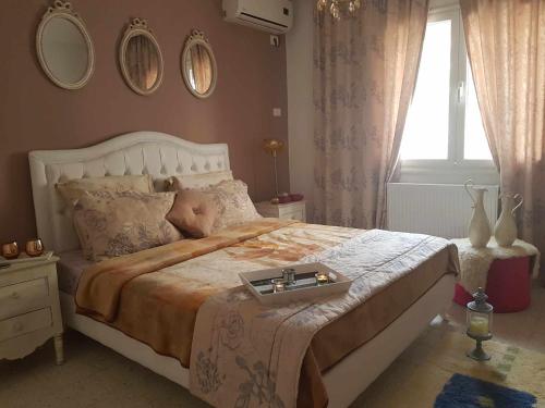 Un dormitorio con una cama grande y una bandeja. en Appartement luxueux au bord de la mer, en Nabeul
