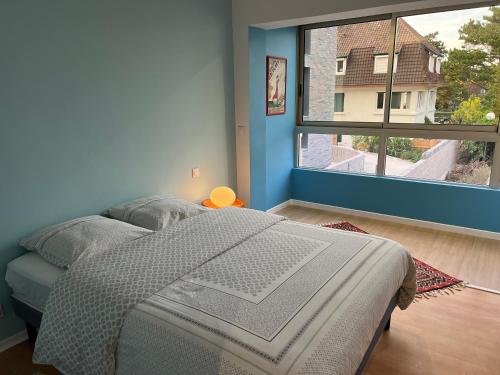 a bedroom with a bed and a large window at O2 in Le Touquet-Paris-Plage