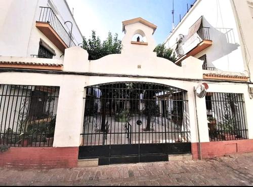 a white building with a gate in front of it at Habitaciones en Centro Histórico Alameda in Seville