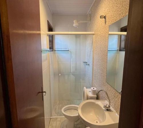 a bathroom with a shower and a toilet and a sink at Recanto da Gabi in Ubatuba